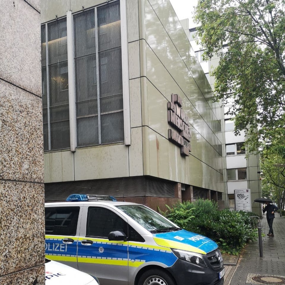 Parkende Polizeiautos vor dem Gebäude des OLG Frankfurt