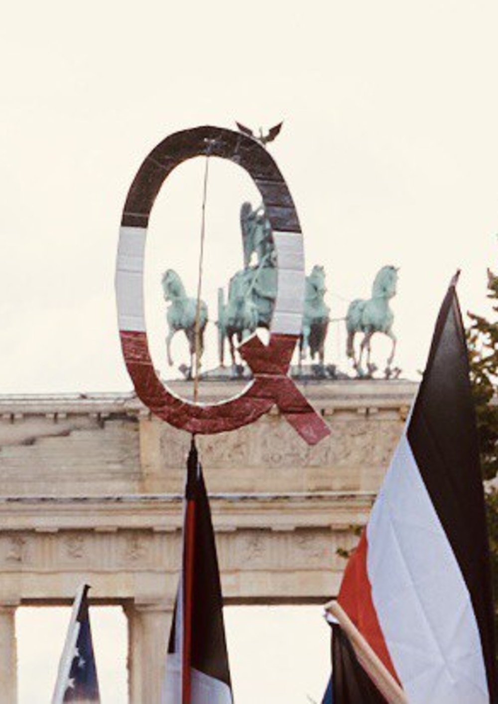 Vor dem Brandenburger Tor tragen Demonstrant:innen Reichsflaggen und den Buchstaben Q in Reichsflaggen-Optik. Das Q steht für "QAnon". 